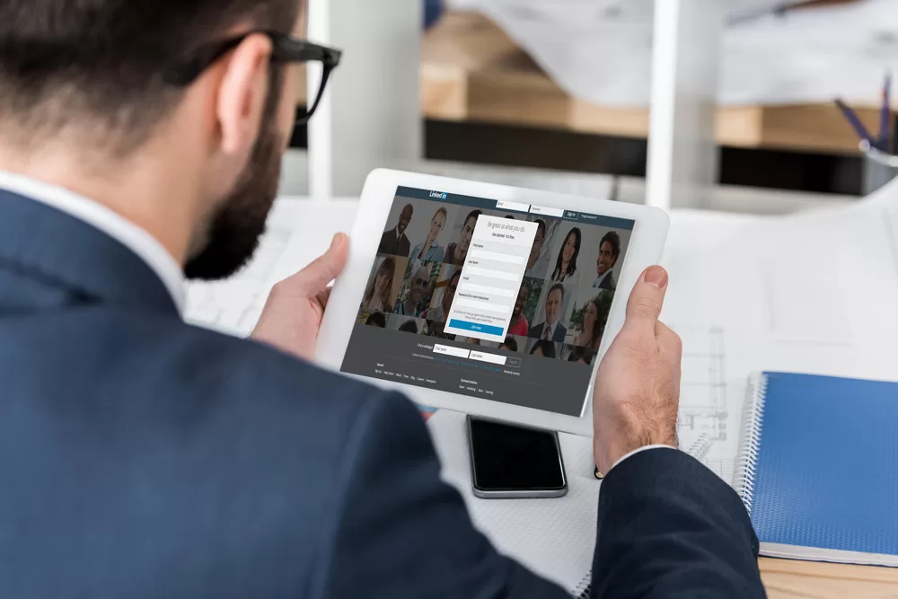 Businessman looking at LinkedIn login on tablet