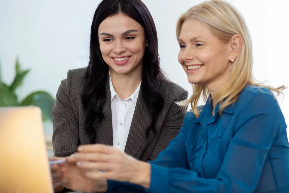 2 women at a computer smiling