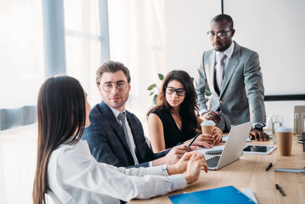 Diverse executives in a modern boardroom discussing governance strategy around a conference table, representing common boardroom challenges and best practices.